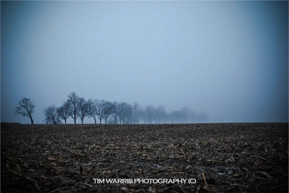 Dramatic storm clouds in dark gray and white formations over calm turquoise ocean water with distant horizon line